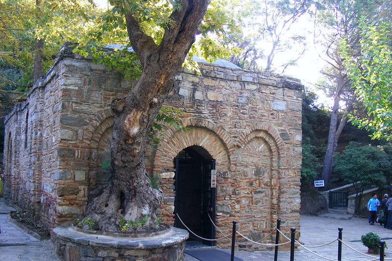 tour-por-turquia (12) El exterior y la entrada de la histórica Casa de la Virgen María, ubicada en una zona boscosa en Selçuk, İzmir, con su arquitectura de piedra y ladrillo.