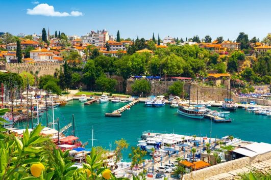 Vistas panorámicas del puerto deportivo de Antalya Kaleiçi, excursiones diarias en barco y rutas de alquiler de yates por el Mediterráneo. Turismo marítimo en el puerto histórico, visitas al casco antiguo y vacaciones de verano en la costa sur de Turquía; hoteles boutique con vistas al puerto y populares actividades de paseos en barco.