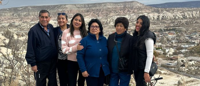 Excursión invernal a Capadocia; sesión fotográfica detallada al aire libre de un viajero frente a un valle nevado y las emblemáticas chimeneas de hadas.