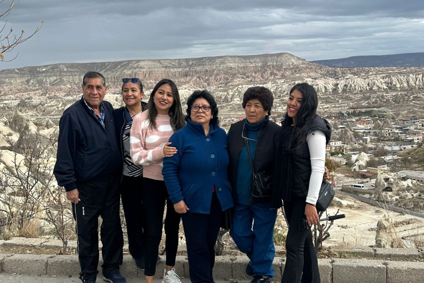 Excursión invernal a Capadocia; sesión fotográfica detallada al aire libre de un viajero frente a un valle nevado y las emblemáticas chimeneas de hadas.