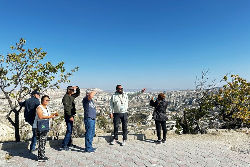 Un grupo de viajeros se reunió en la atmósfera de cuento de hadas de Capadocia, celebrando la amistad y la alegría. Un momento feliz se fundió con los valles y colinas que se extendían al fondo.