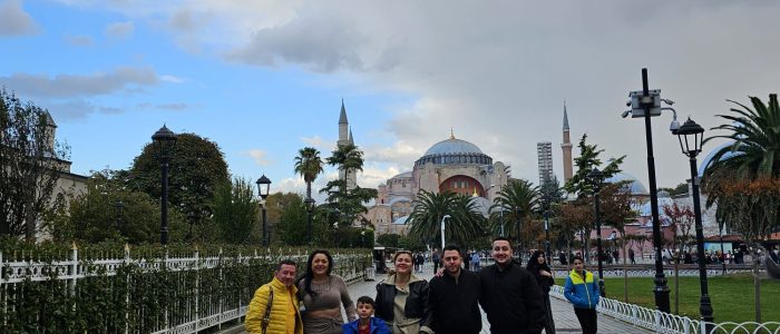 Un grupo de visitantes posa en la plaza Sultanahmet de Estambul, con la Gran Mezquita de Santa Sofía al fondo.