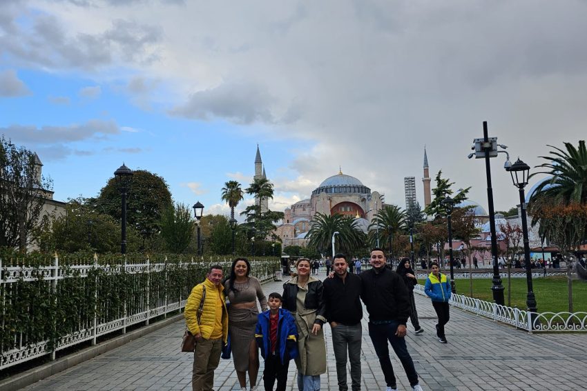 Un grupo de visitantes posa en la plaza Sultanahmet de Estambul, con la Gran Mezquita de Santa Sofía al fondo.