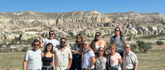 "Un numeroso grupo de turistas se congregó frente a las singulares formaciones rocosas y el paisaje del valle de Capadocia."